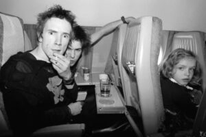 Johnny Rotten and Sid Vicious of the Sex Pistols on a plane with an unknown little girl from London to Brussels, November 1977.