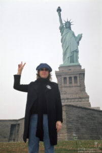 John Lennon in front of The Statue of Liberty, NYC. October 30, 1974. © Bob Gruen / www.bobgruen.com Please contact Bob Gruen's studio to purchase a print or license this photo. email: info@bobgruen.com